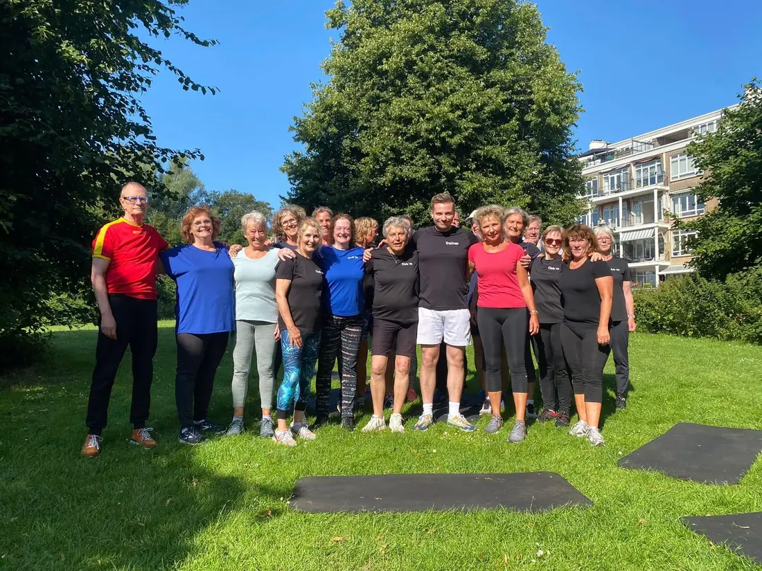Lid en trainer geven een high five na een buitentraining bij Club Vit, Den Haag
